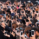 Dozens of people use their smartphone to take photos of the L'Oreal fashion show on the Champs Elysees avenue in 2017
